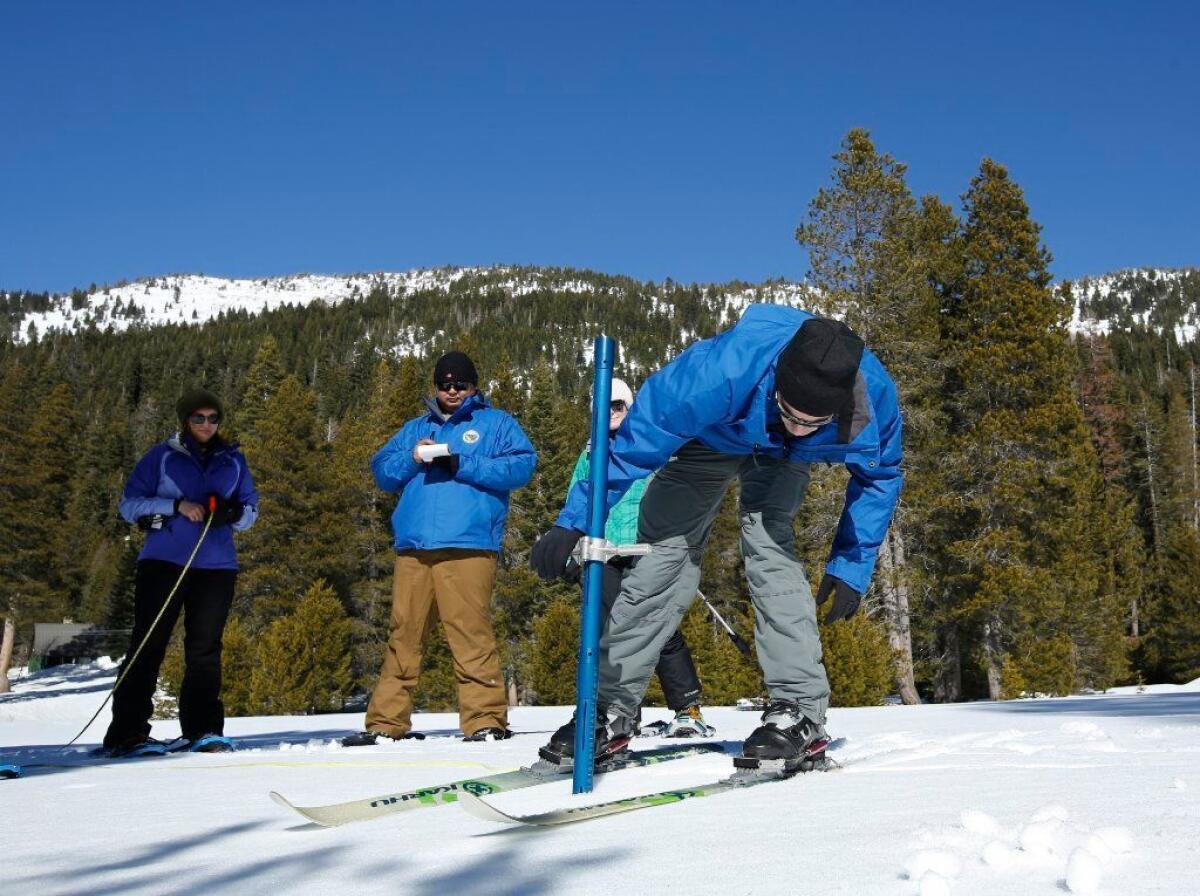 John King of the Department of Water Resources, right, checks the snowpack depth during the second manual snow survey of the season at the Phillips station Thursday near Echo Summit, Calif.