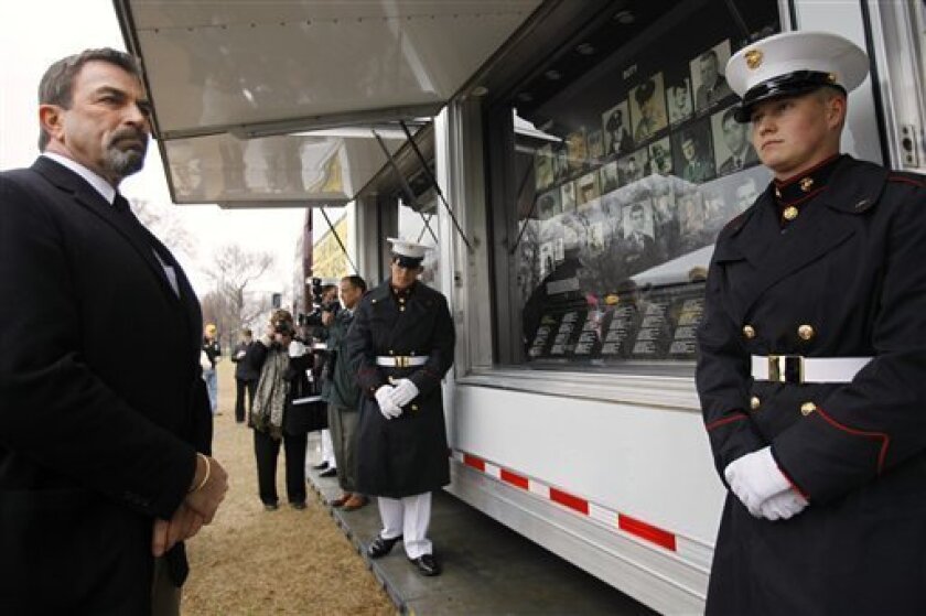 Actor Tom Selleck, left, attends an event unveiling a traveling exhibit called "The Wall That Heals", part of the traveling Vietnam Veterans Memorial and Museum, in Washington, Thursday, March 26, 2009. At right is U.S. Marine Corps Lance Cpl. Nick Adams, 21. (AP Photo/Jacquelyn Martin)