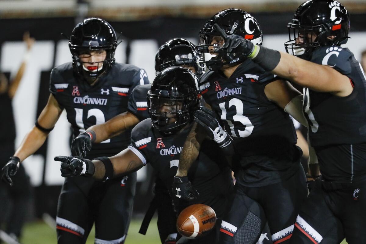 Cincinnati wide receiver Trent Cloud (13) celebrates with his teammates after scoring a first-half touchdown against Central Florida on Friday.