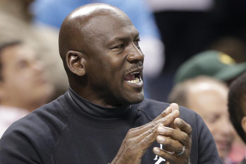 Charlotte Hornets owner Michael Jordan applauds during a game against the Washington Wizards on Feb. 5.