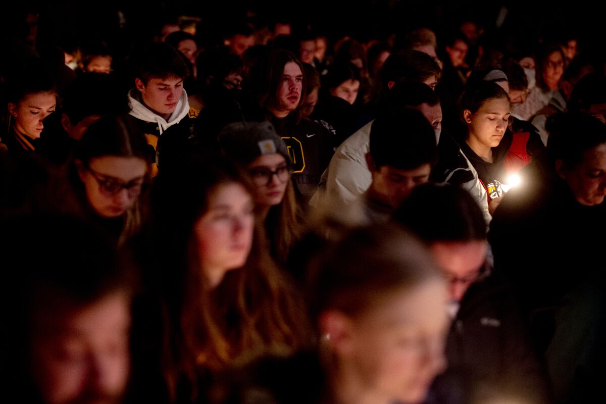 Oxford High School sophomore Allison Hepp, 15, holds a candle as she bows her head in prayer during a vigil after the Oxford High School school shootings, Tuesday, Nov. 30, 2021, at LakePoint Community Church in Oxford, Mich. (Jake May/The Flint Journal via AP)