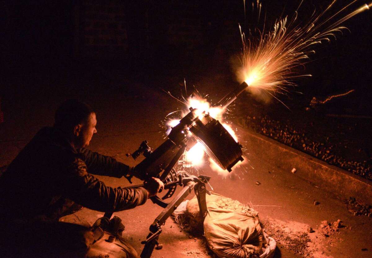 A Ukrainian soldier fires an automatic grenade launcher near the Donetsk-area village of Peski on Monday. Ukraine's armed forces on Tuesday rejected allegations that they have used cluster bombs in the war against pro-Russia separatists.