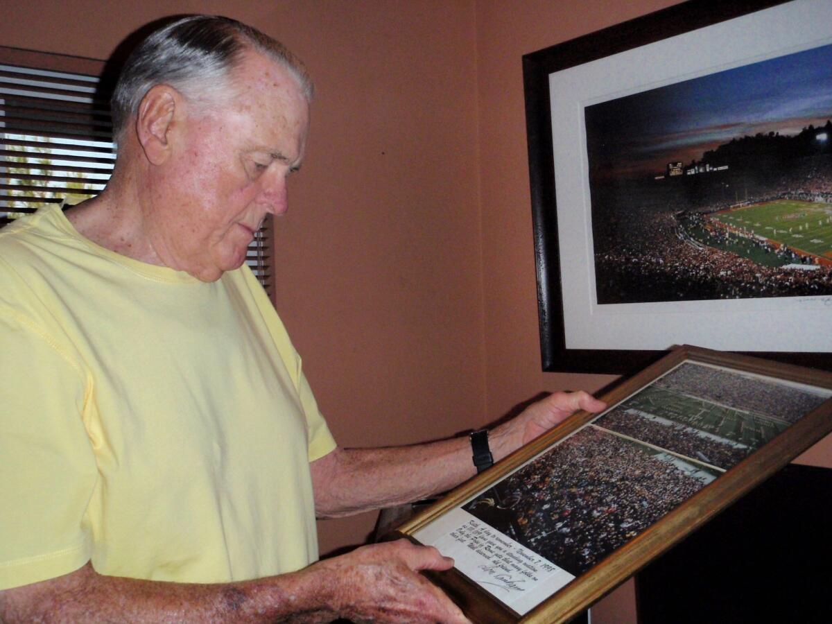 Former ABC Sports college football broadcaster Keith Jackson holds a photo of the Michigan band spelling out "Thanks Keith" during a farewell halftime show. Jackson says current sports broadcasters talk too much.
