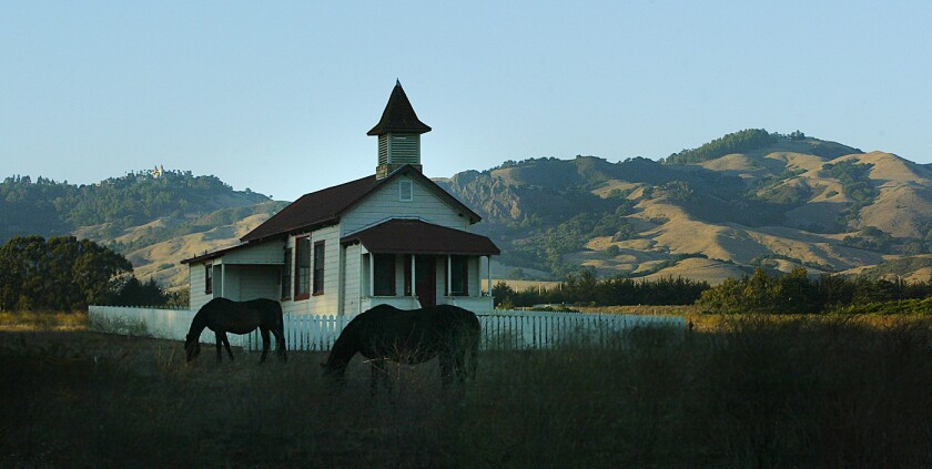An old schoolhouse in historic old San Simeon Village frames some of the 83,000–acre Hearst Ranch.