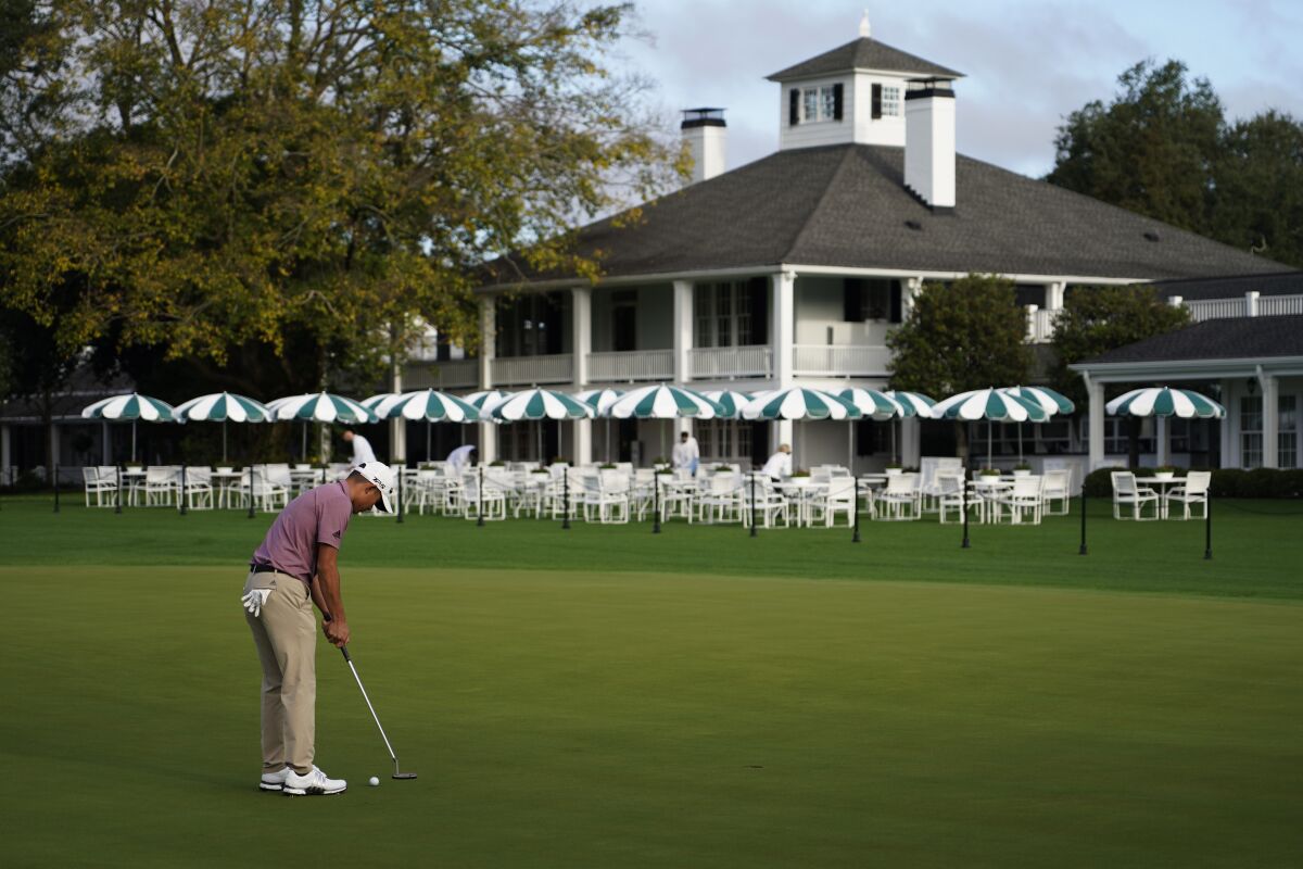 Collin Morikawa practices on the putting green outside the Augusta National clubhouse.