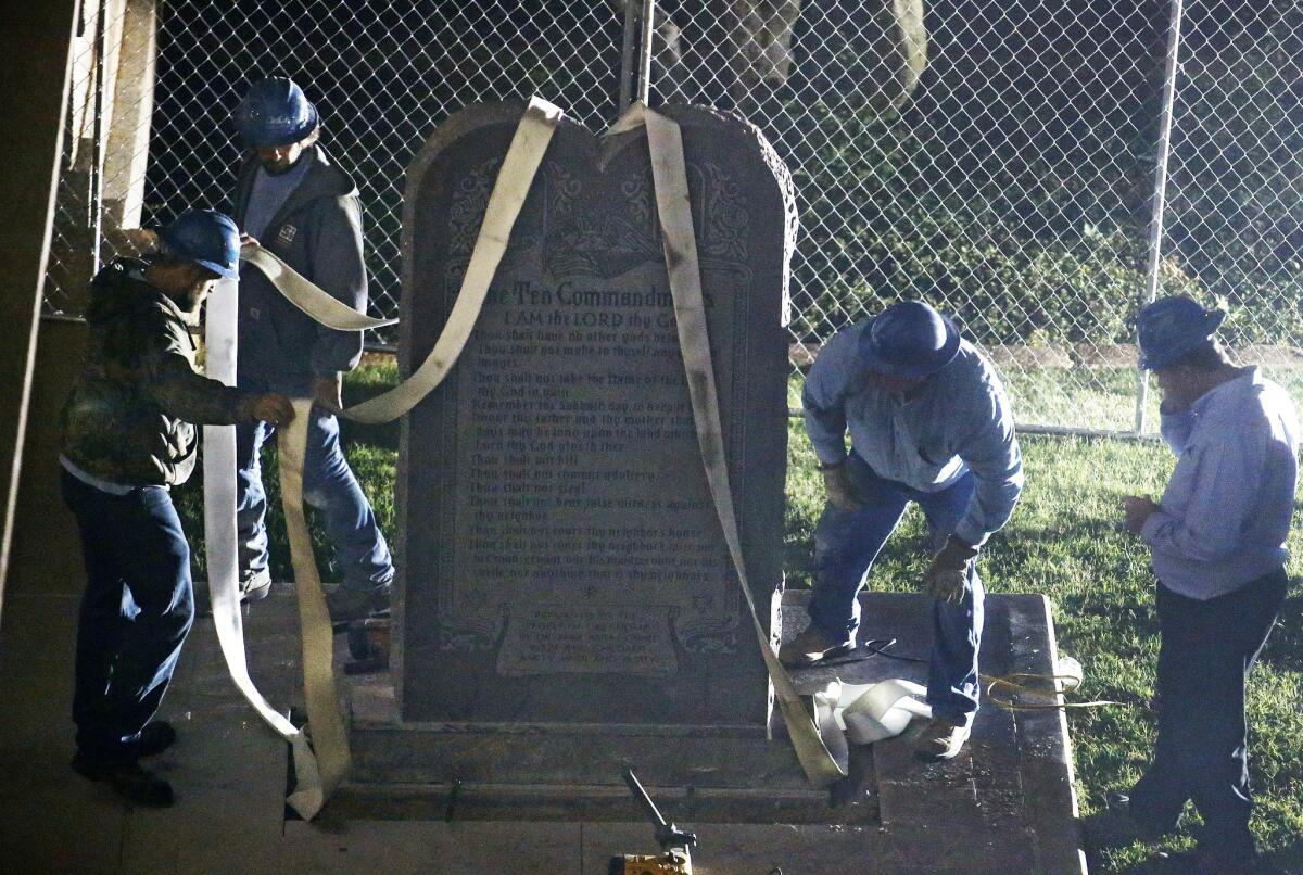 Workers remove the controversial Ten Commandments monument from the grounds of the state Capitol in Oklahoma City.