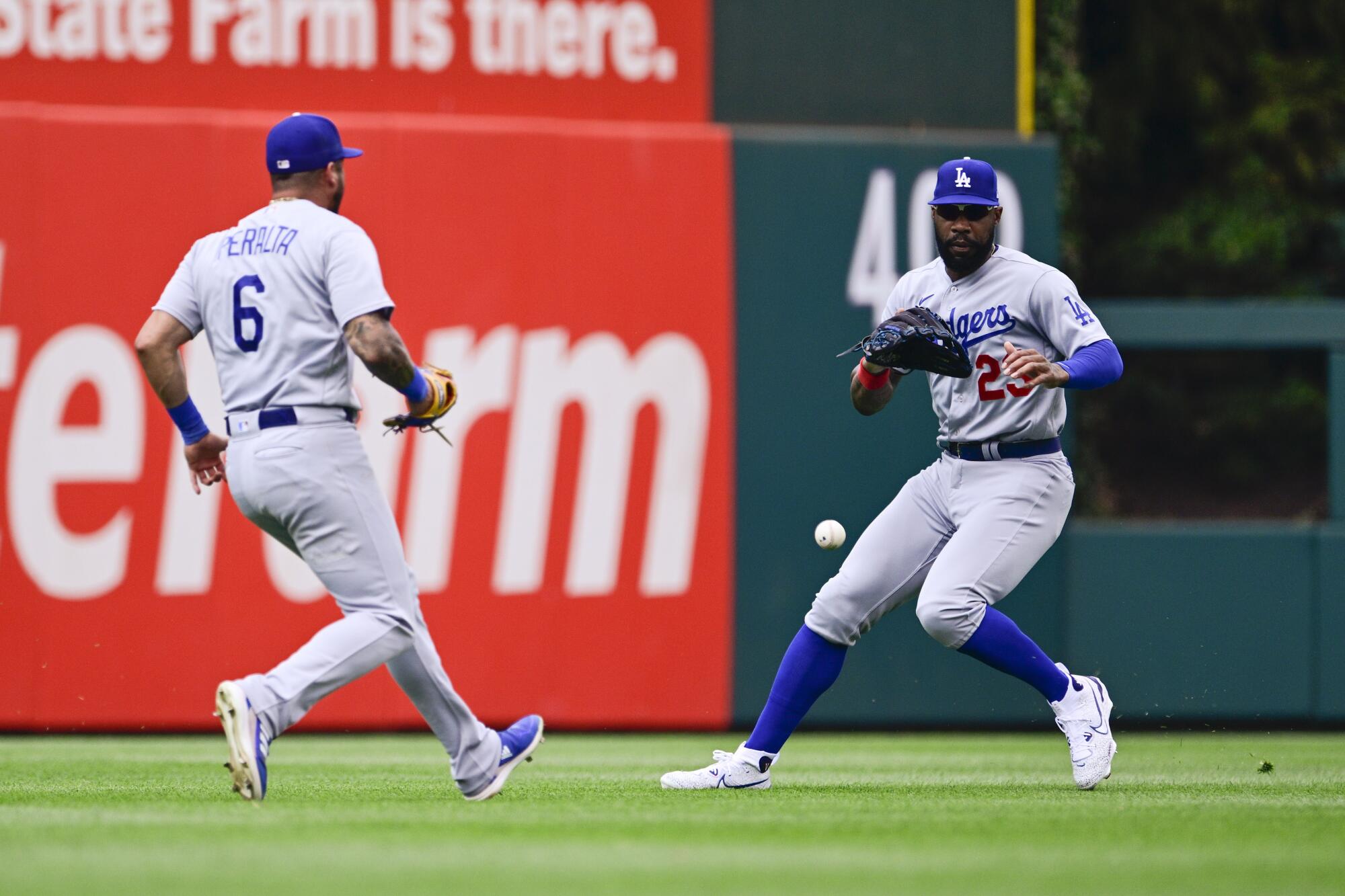 two baseball players run to catch a baseball