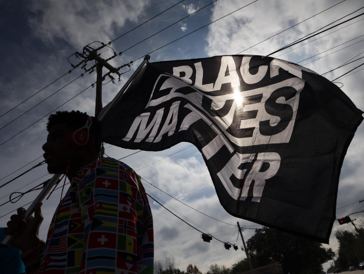 MD Crawford carries a Black Lives Matter flag before a march in La Marque, Texas, to protest the shooting of Joshua Feast