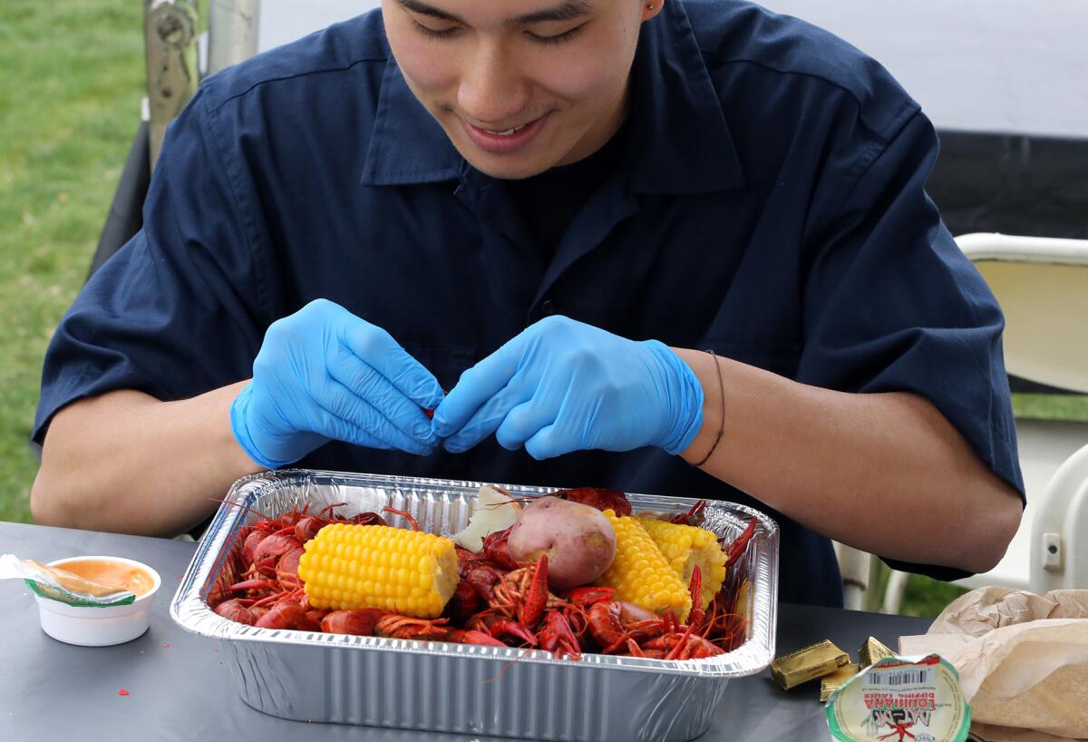 Nick Truong, 20, of Westminster, peels crawfish at Fountain Valley Sports Park on Friday.