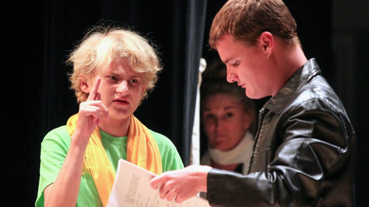 Students Liam Porter (left, as the Little Prince) and Reid Moriarty (as the Pilot) run through a scene as director Samantha Ginn watches.