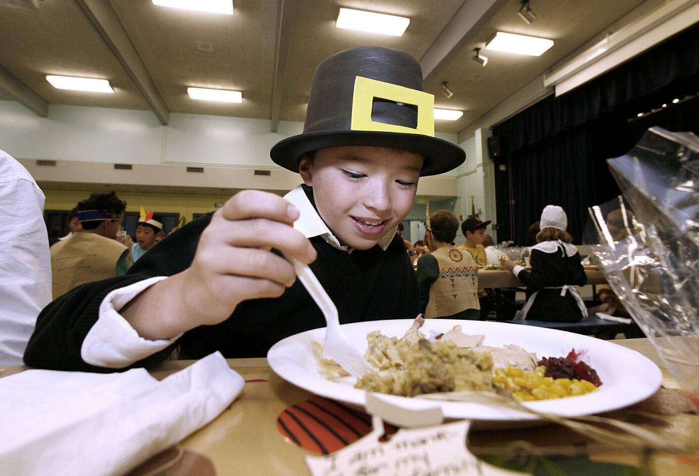 Fifth grader Jason Suh enjoys a Thanksgiving meal during lunch at La Canada Elementary School in La Canada on Friday, Nov. 16, 2012. The annual event has the 5th grade classes dress up in costumes and are served the meal by volunteer parents.
