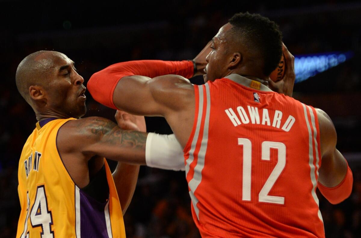 Kobe Bryant and Dwight Howard tangle during the fourth quarter of the Lakers' season-opening loss to the Houston Rockets, 108-90, at Staples Center.