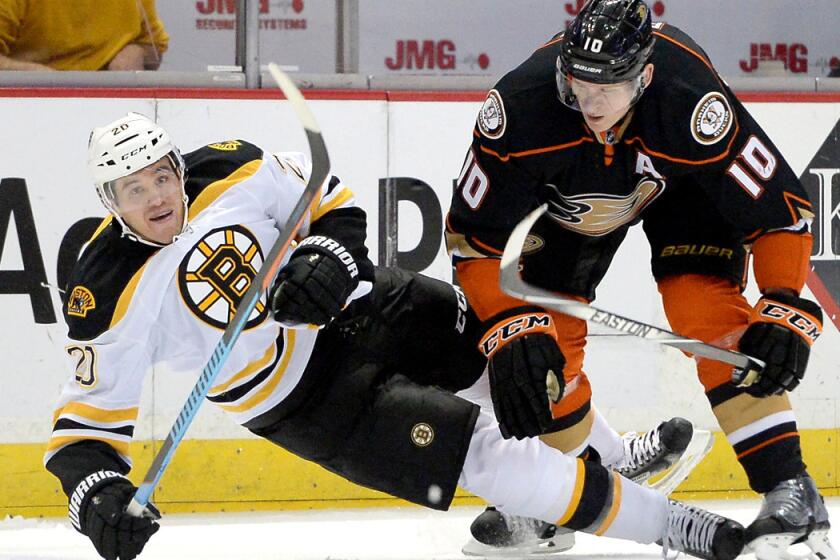 Ducks right wing Corey Perry (10), knocking down Boston's Daniel Paille with a check, was injured in the first period of Friday night's game in Minnesota.