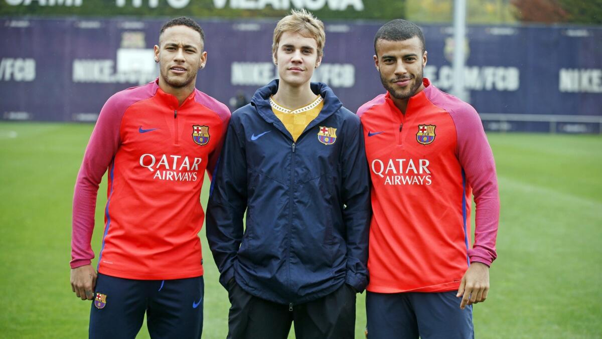 Justin Bieber connected with FC Barcelona's Neymar, left, and Rafinha Alcantara during an FC Barcelona training session Monday.