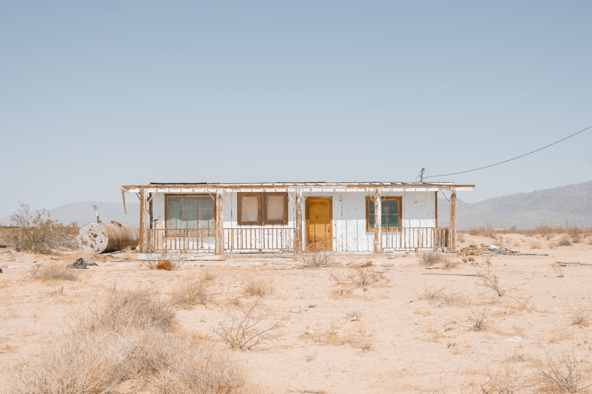 An abandoned boarded up home in the desert.