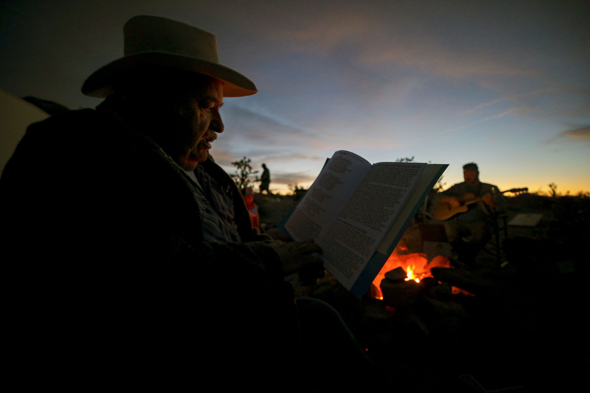 April 3: Home missionary Larry Craig looks at paperwork, sitting near a campfire.