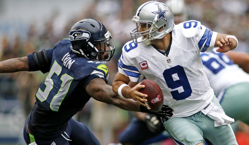Cowboys quarterback Tony Romo scrambles to avoid the rush of Seahawks linebacker Bruce Irvin in a 30-23 victory in Seattle. Romo and the Cowboys travel to Philadelphia this week for an NFC East first-place showdown.