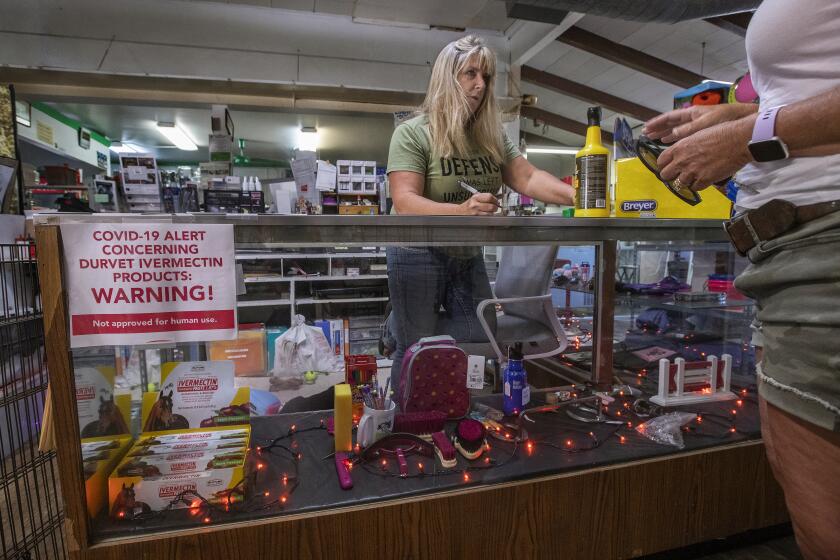 ROLLING HILLS, CA - SEPTEMBER 13, 2021: Tracey Savich, left, owner of Rolling Hills General Store, helps a customer inside her store. Savich said that she couldn't tell if a customer was joking when he came into her store asking for over the counter ivermectin, an anti-parasitic drug, commonly used to deworm horses, cows and other livestock that has been controversially touted as a preventative and treatment for COVID-19, particularly among those who remain skeptical about the vaccine. While its efficacy against COVID-19 has been debunked, some Californians have managed to acquire prescriptions from their healthcare providers. (Mel Melcon / Los Angeles Times)