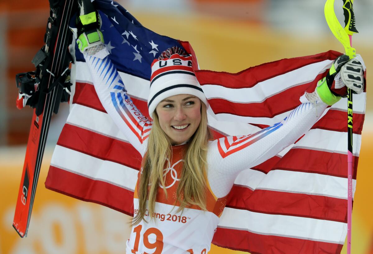 FILE - Silver medal winner Mikaela Shiffrin, of the United States, poses during the flower ceremony.