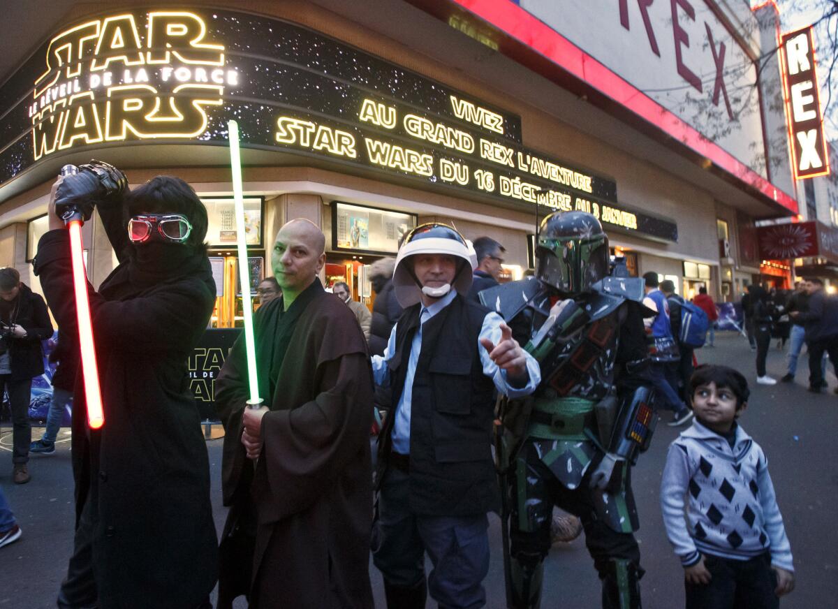 People dressed in character pose outside the Grand Rex movie theater before a screening of "Star Wars: The Force Awakens"in Paris.