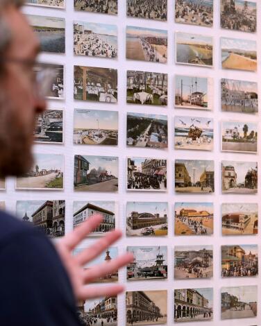 A man stands next to a display of vintage postcards at the Venice Heritage Museum.