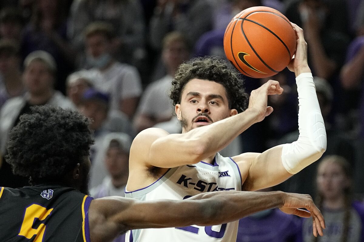 Kansas State's Ismael Massoud, right, looks to pass under pressure from Albany's Jamel Horton (5) during the first half of an NCAA college basketball game Wednesday, Dec. 1, 2021, in Manhattan, Kan. (AP Photo/Charlie Riedel)