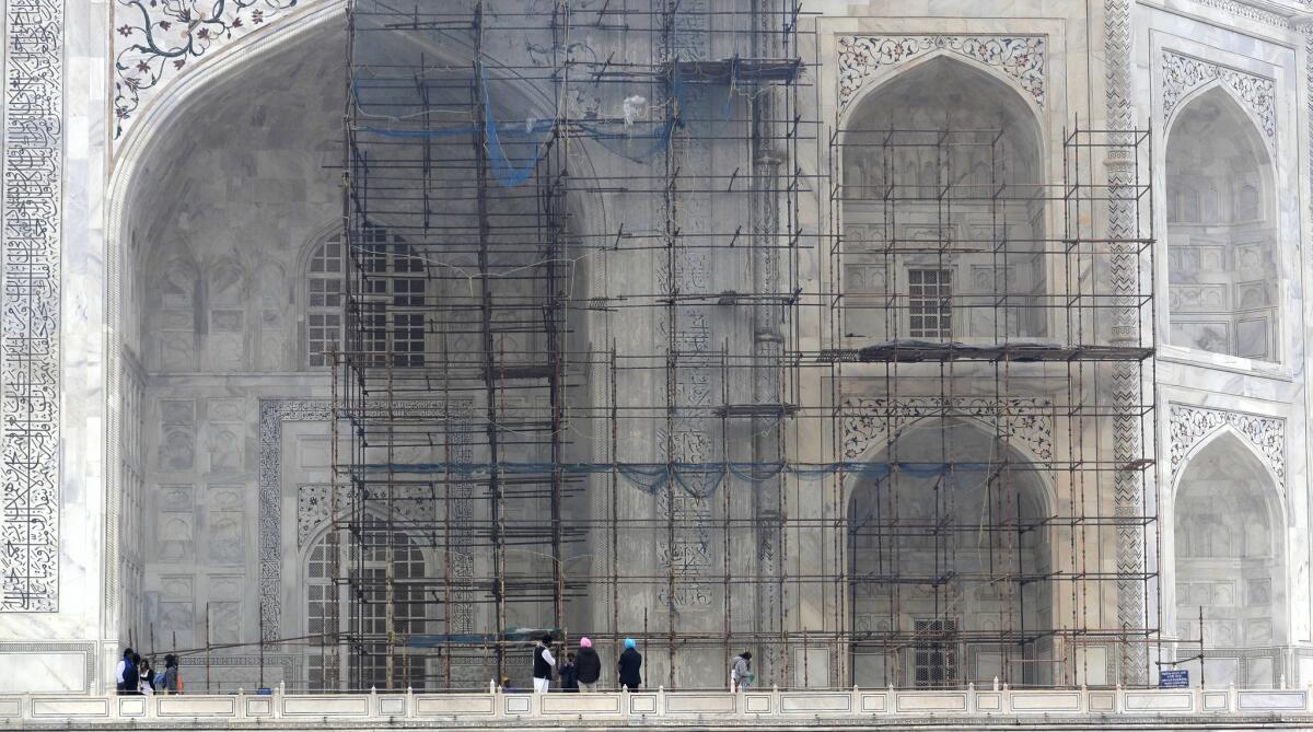 In this photo from Dec. 5, 2017, scaffolding covers a marble wall of the Taj Mahal where workers applied a clay mixture to remove discoloration caused by pollution.