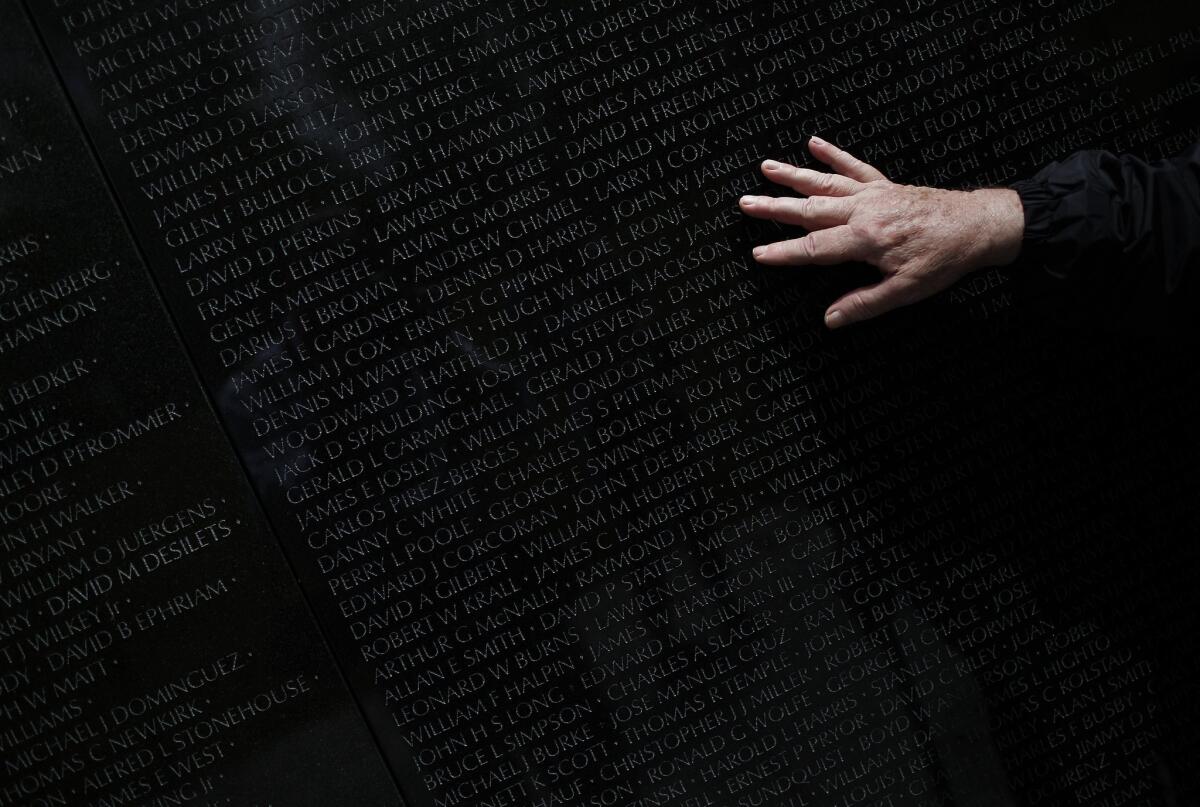 Hermann Zapf, the typography designer of the font used on the Vietnam Veterans Memorial, has died. In this image, two-tour Vietnam veteran Steve Moczary searches for the name of a friend.