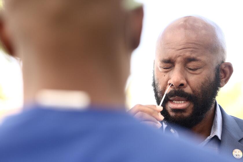 CARSON, CA - APRIL 28, 2020 - - California Assemblyman Mike A. Gipson, of the Sixty-Fourth District, does self-testing at a new drive-up testing site for COVID-19 outside the East Wing of the Congresswoman Juanita Millender-McDonald Community Center in Carson on April 28, 2020. Free COVID-19 testing is available to all city residents thanks to a partnership between the city and US Health Fairs. Carson is the first Southern California city to offer free testing to all its residents. Mayor Albert Robles and members of the Carson City Council also did self-testing at the opening of the new test site. (Genaro Molina/Los Angeles Times)