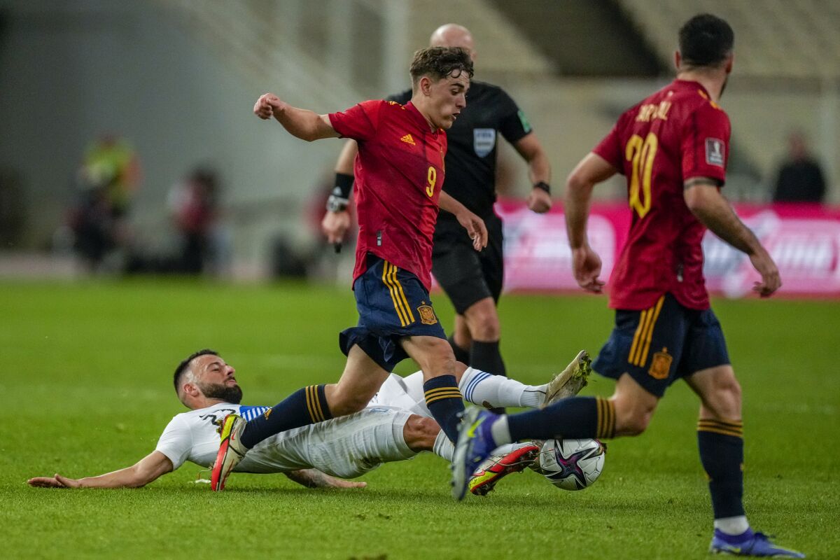 Spain's Gavi, second left, fights for the ball with Greece's Manolis Siopis during the World Cup 2022 group B qualifying soccer match between Greece and Spain at the Olympic stadium in Athens, Greece, Thursday, Nov 11, 2021. (AP Photo/Thanassis Stavrakis)