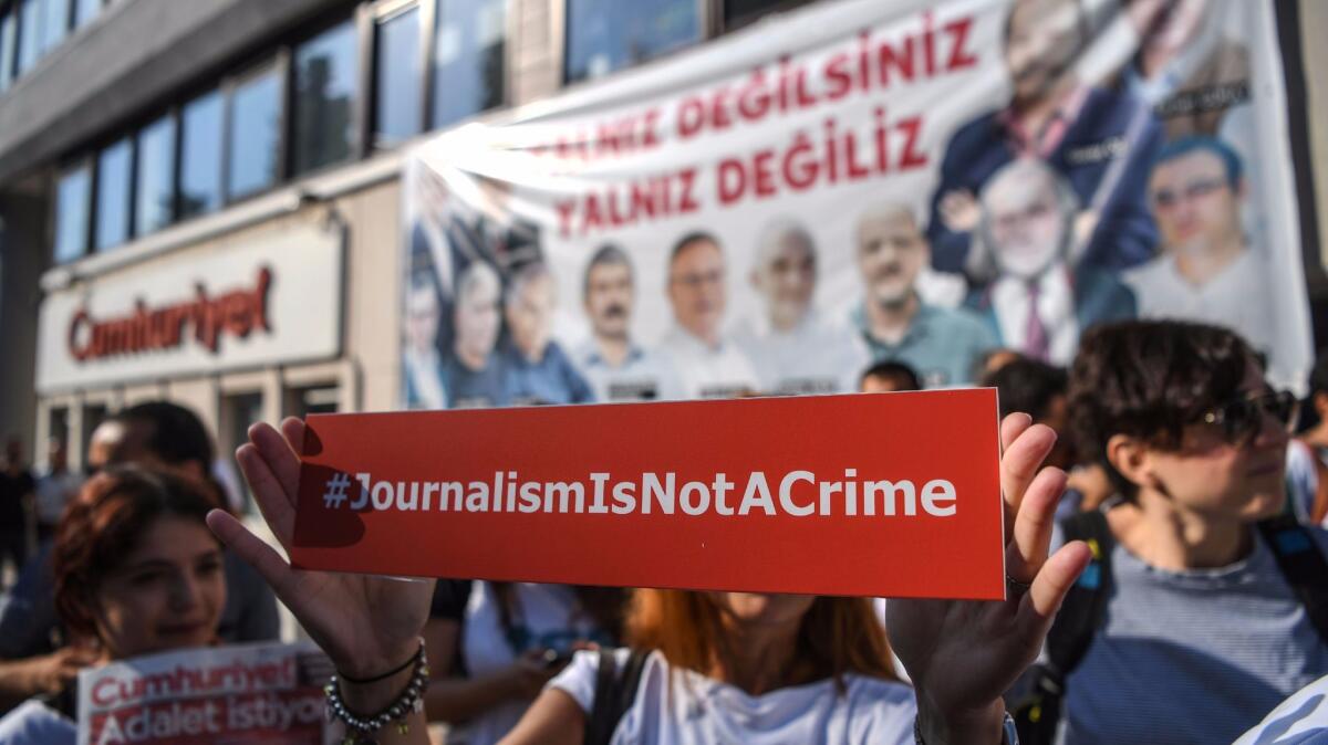 A journalist holds a banner on Monday outside the headquarters of opposition daily newspaper Cumhuriyet in Istanbul.