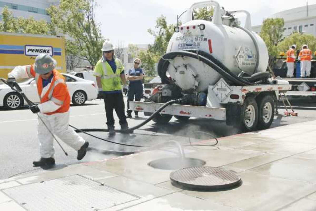 Ocean Blue Enivronmental Services, Inc. workers clean up the disinfected are on Alameda Avenue near the Buena Vista Street intersection in Burbank on Wednesday. A truck was delivering diesel fuel and appeared that his shaft hit a fuel line and leaked.