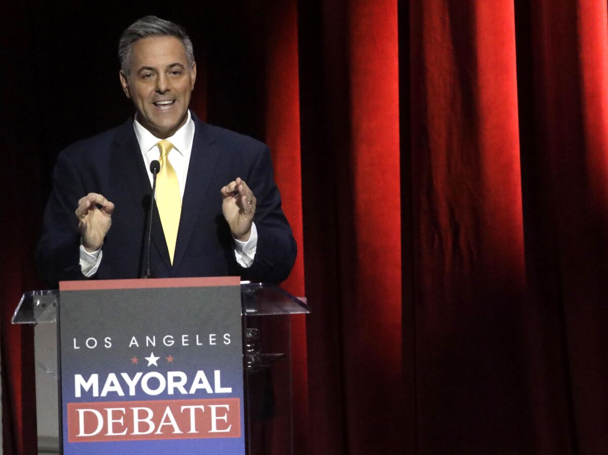 City Councilman Joe Buscaino speaks at a lectern that reads "Los Angeles Mayoral Debate."