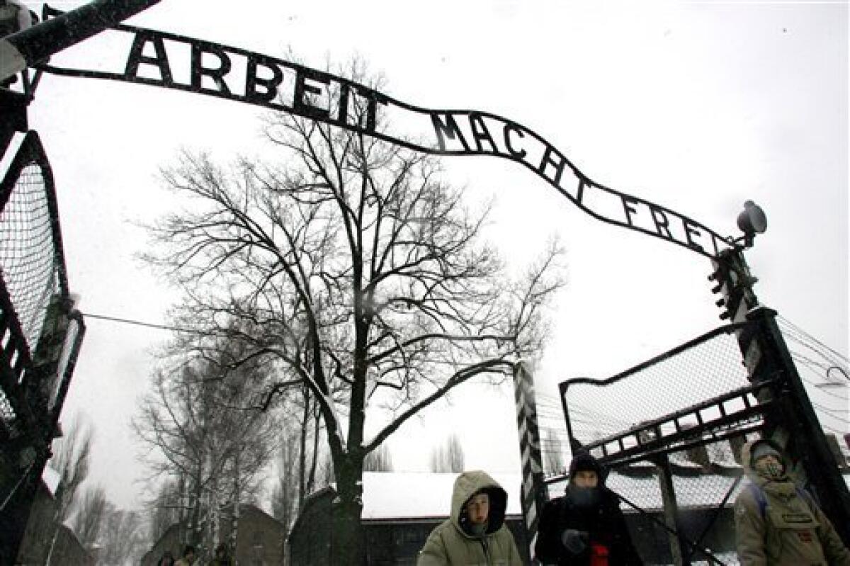 FILE --In a Jan. 26, 2005 file photo visitors walk uhder the sign at the entrance gate of the Auschwitz Nazi concentration camp in Oswiecim, southern Poland. Polish police Friday Dec. 18, 2009 say the infamous iron sign over the gate to the Auschwitz memorial site with the cynical phrase "Arbeit Macht Frei" _ German for "Work Sets You Free" _ has been stolen. (AP Photo/Herbert Knosowski/file)