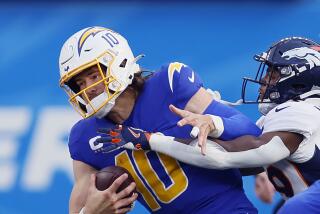 Inglewood, CA - December 10: Chargers quarterback Justin Herbert is sacked by Broncos cornerback.