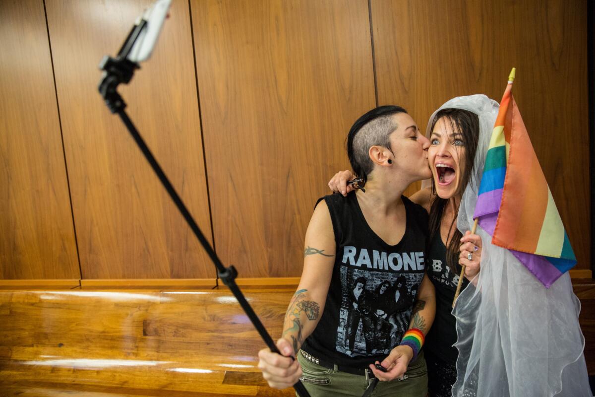 Natalie Novoa, left, and Eddie Daniels, take a selfie while waiting to get married at the L.A. County Registrar branch in Beverly Hills on the day the Supreme Court made its landmark ruling.