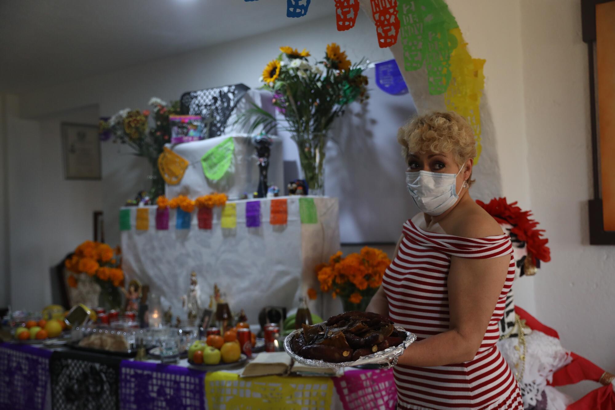 María del Carmen López, prepara una ofrenda por sus familiares 