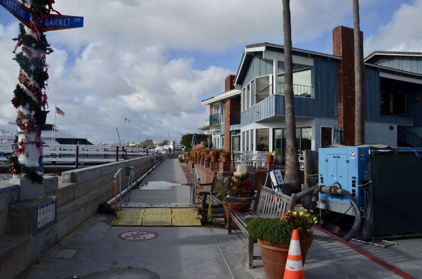 Construction materials and safety ramp encroach on the pedestrian walkway along Balboa Island's South Bayfront.