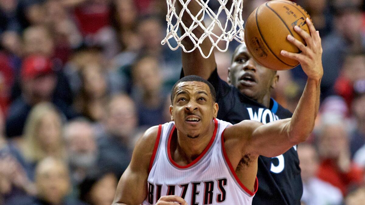 Trail Blazers guard C.J. McCollum gets past Timberwolves center Gorgui Dieng for a layup during a game Jan. 31.
