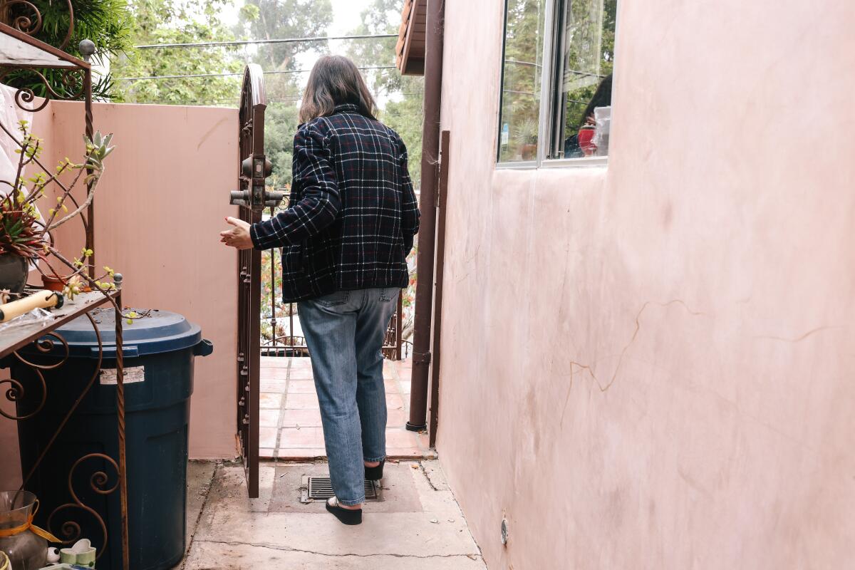 Sharon Goldman walks through the exterior of her home