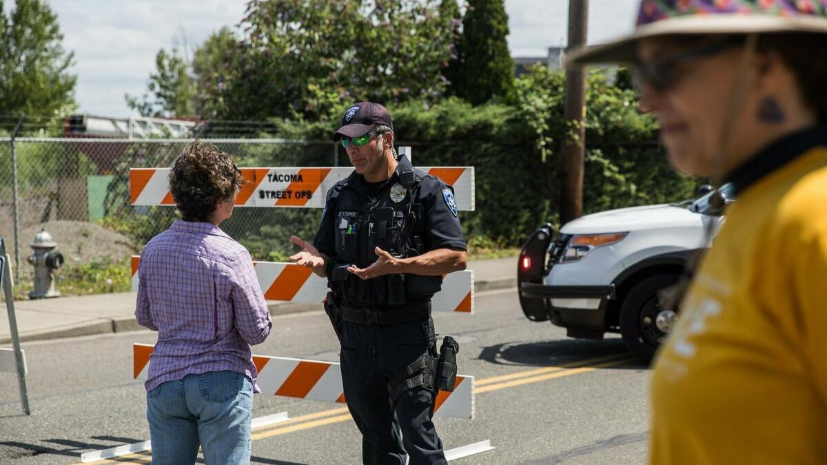 Police Officer Sam Lopez turns away would-be protesters in front of a road block near the Northwest Detention Center, Saturday July 13, 2019 in Tacoma, Wash.