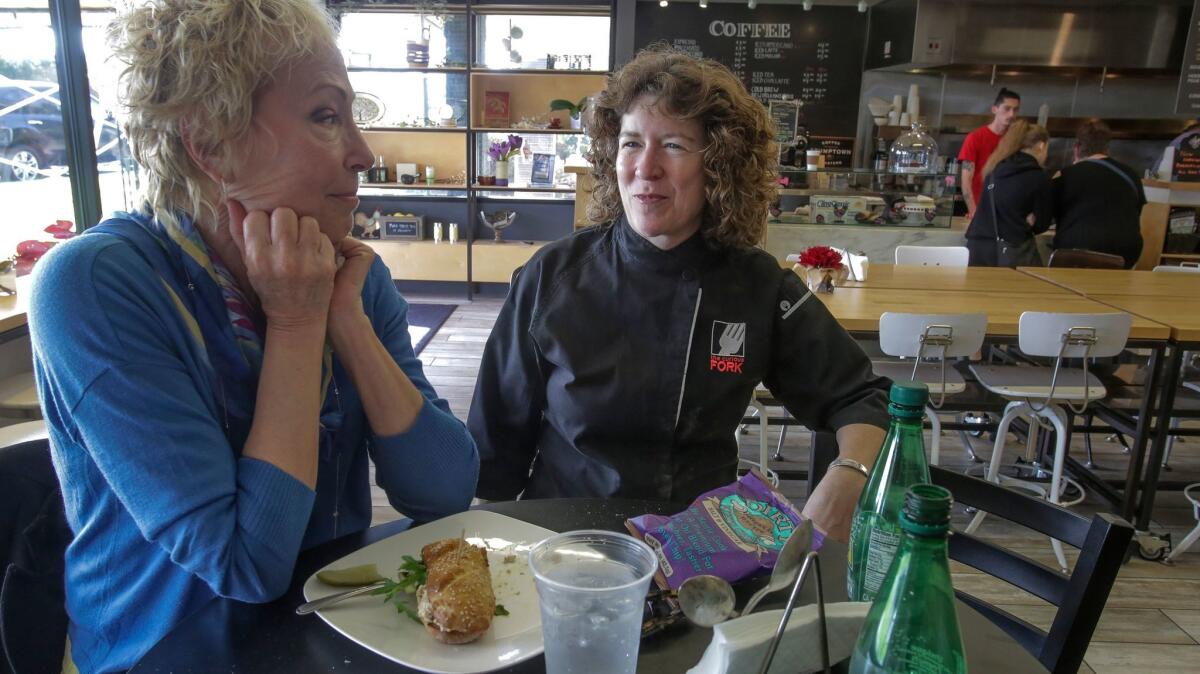 The Curious Fork owner Barbara McQuiston, right, talks with one of her cutomers, Helen Eckmann.