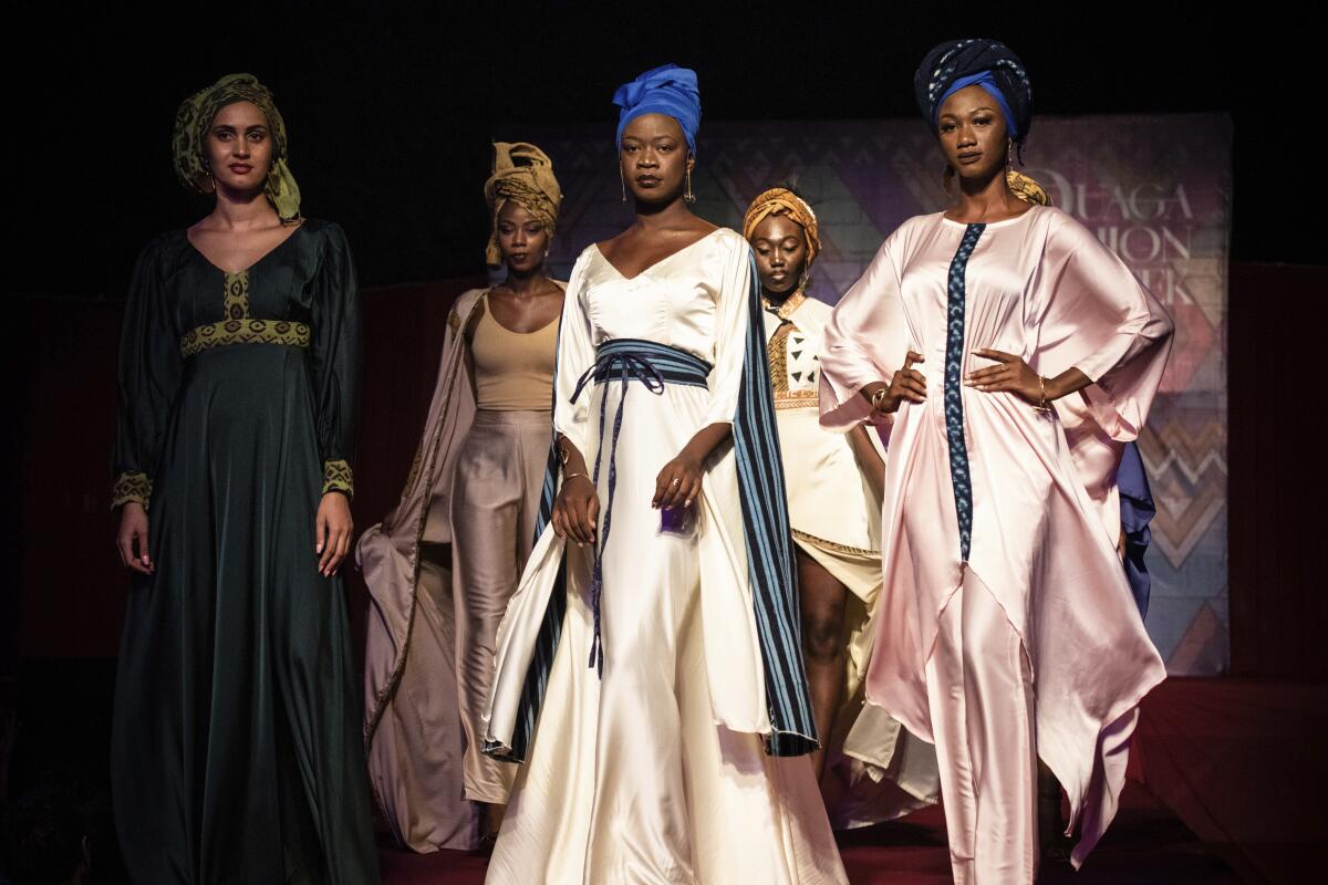 Models participate in the third edition of Ouaga Fashion Week in Ouagadougou, Burkina Faso, Friday May 13, 2022. Over 35 stylists and designers took part in the event, with some shows taking place in the streets of the capital. (AP Photo/Sophie Garcia)