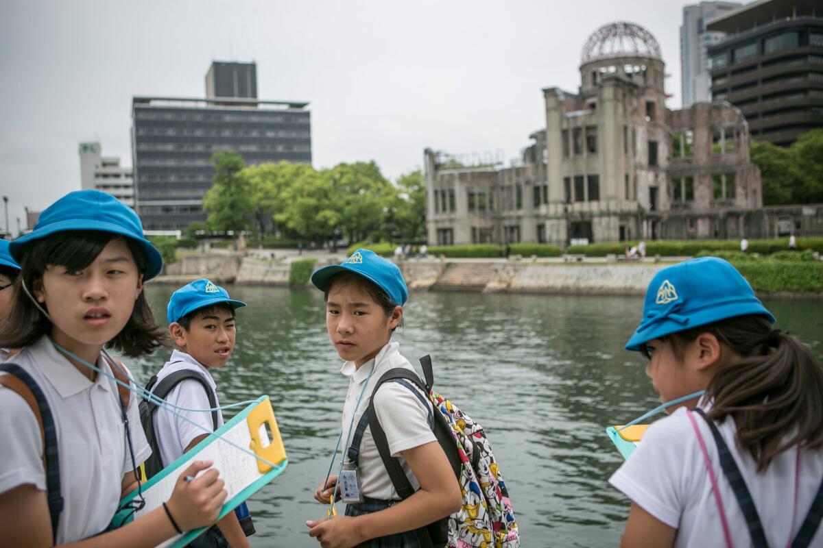 Schoolchildren write down what a guide says at the site of the Atomic Bomb Dome on May 26, 2016, in Hiroshima, Japan.