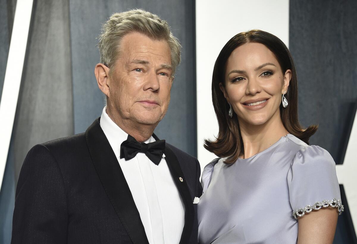 David Foster poses in a black tuxedo with Katharine McPhee smiling in a gray dress.
