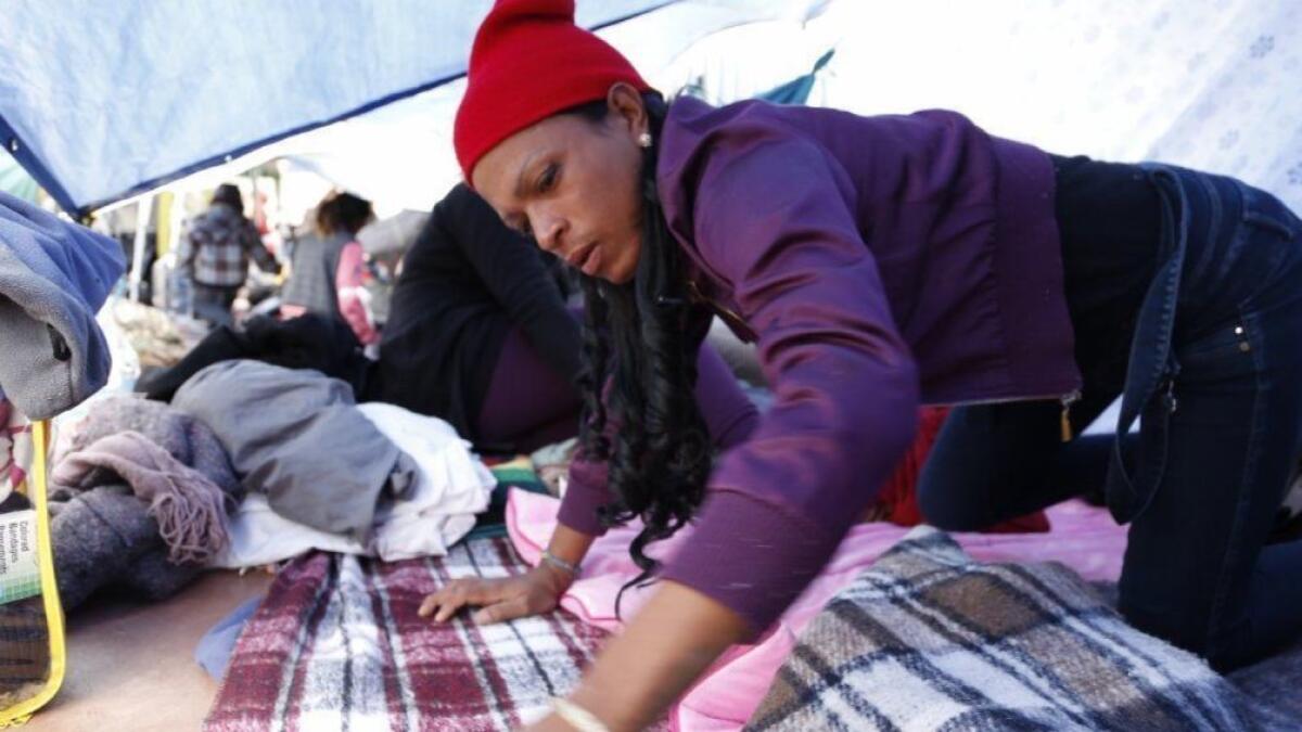 A group of transgender women traveling with a caravan of Central Americans takes shelter underneath a tarp.