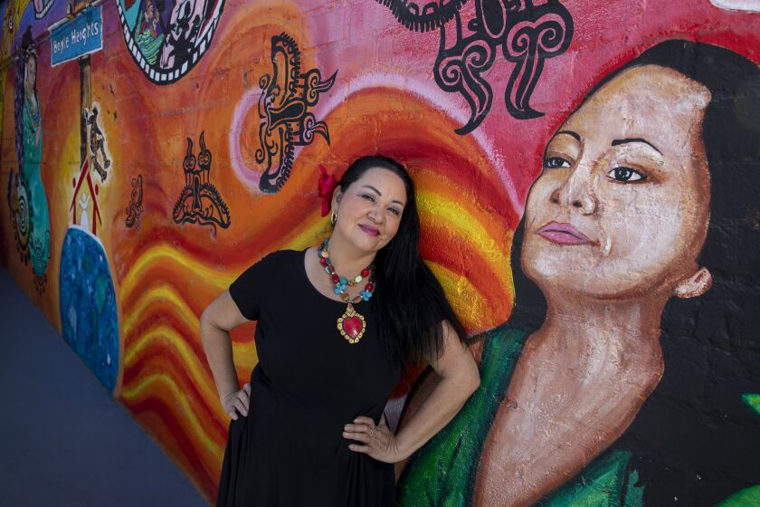 BOYLE HEIGHTS, CA - JULY 31, 2021- Founding artistic director Josefina Lopez sits for portraits outside the theatre with a mural of herself at Casa 0101 Saturday, July 31, 2021 in Boyle Heights, CA. (Brian van der Brug / Los Angeles Times)