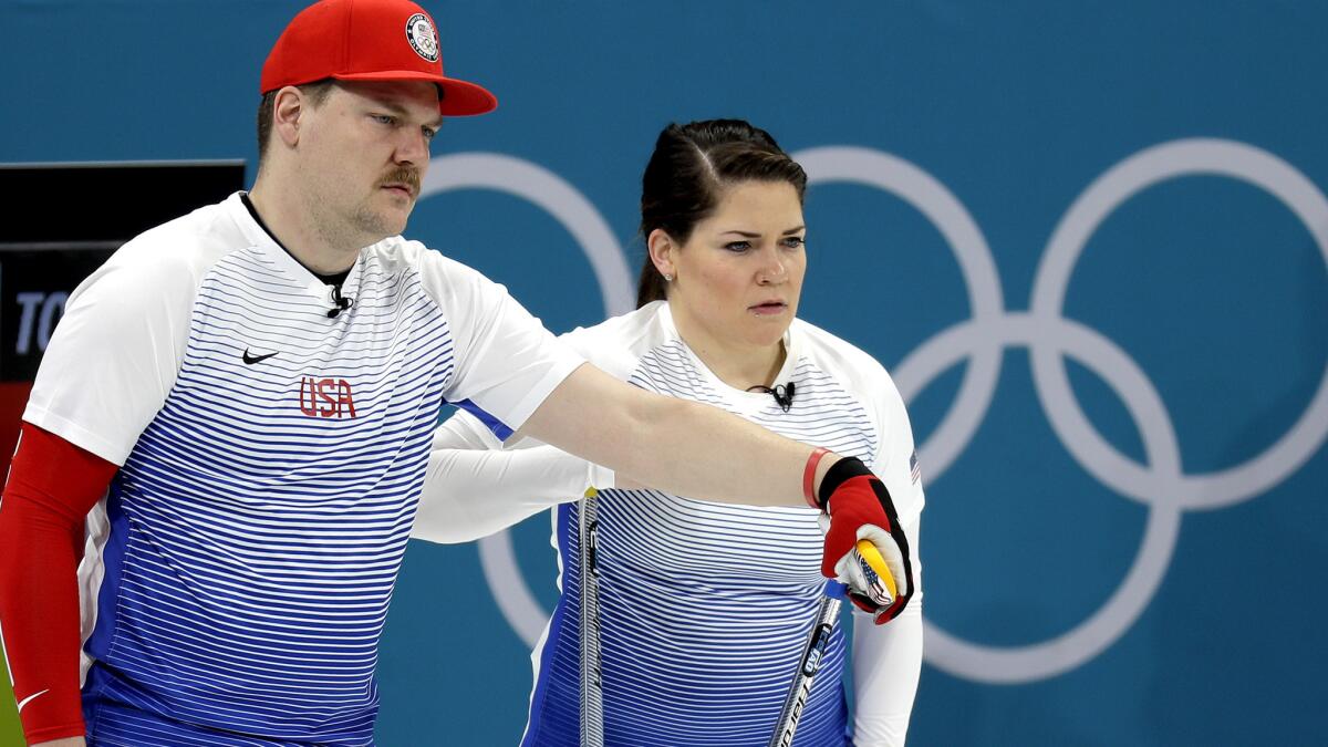 Matt and Becca Hamilton watch the team from Finland take their turn during a mixed doubles curling match Sunday.