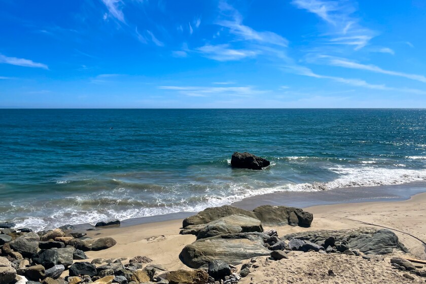 A small sandy beach with boulders.