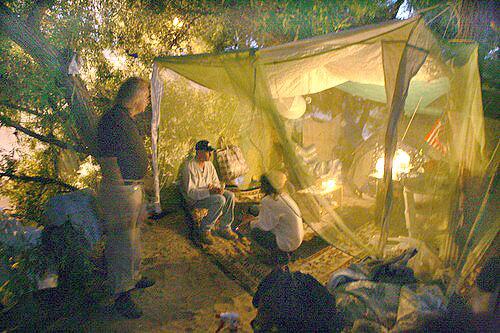 HOUSE CALL: River Ron Schneider, left, visits at night with Robin Country Boatner, middle, and Suzie Blatt, at the couples tent along the Los Angeles River.